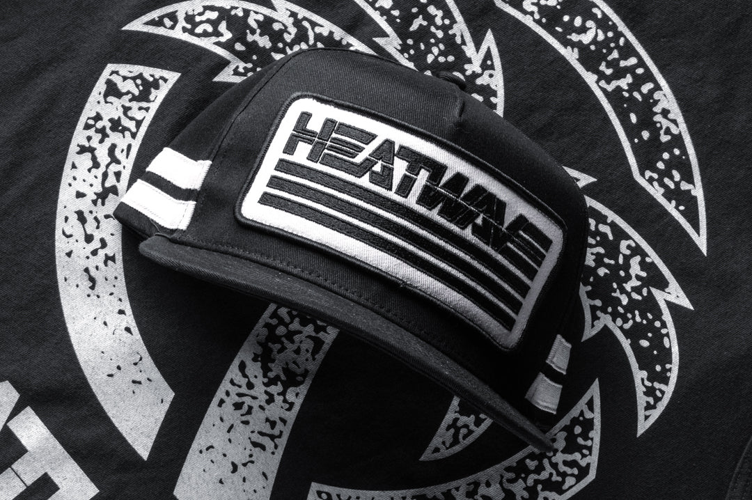 Frontside shot of the Heatwave Alloy Hat lying on top of the Alloy shirt.