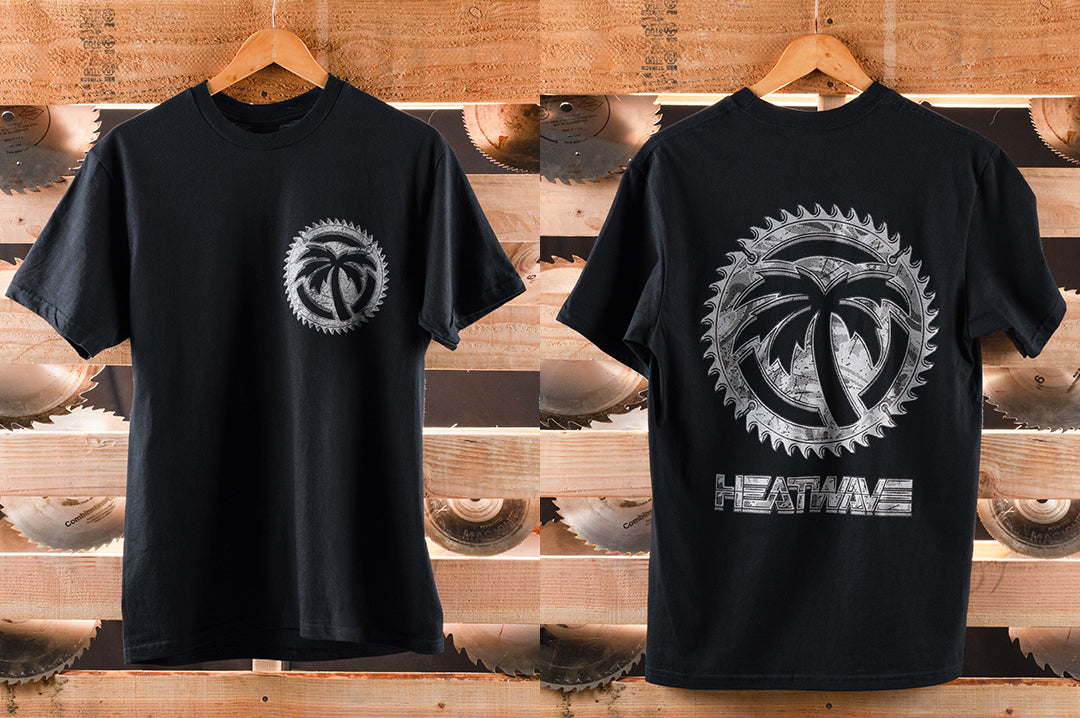 Black t-shirt with a metallic logo and text on a wooden background