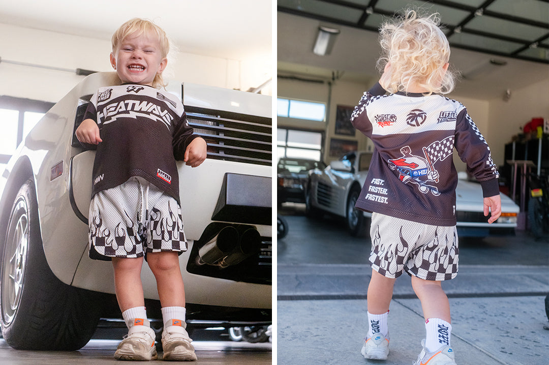 Child wearing the Little Trouble x Heat Wave Kids Long Sleeve Jersey - Black showing the front and back side