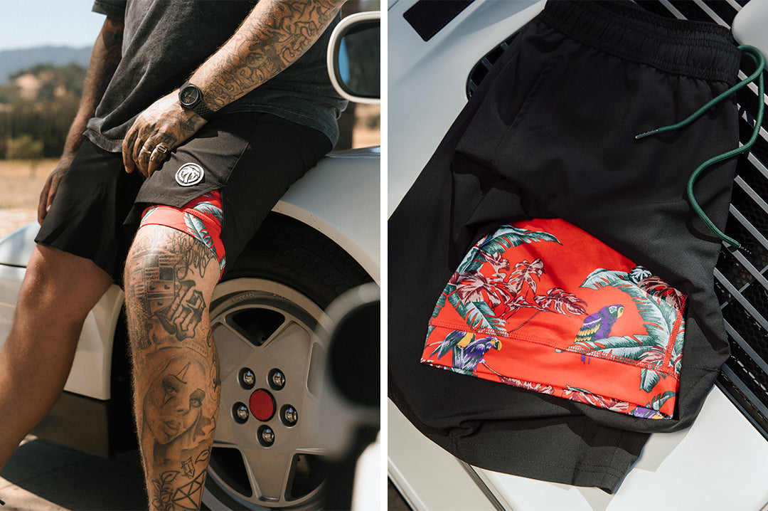 Man wearing the Heat Wave Magnum Performance Shorts - Black and the shorts sitting on a car