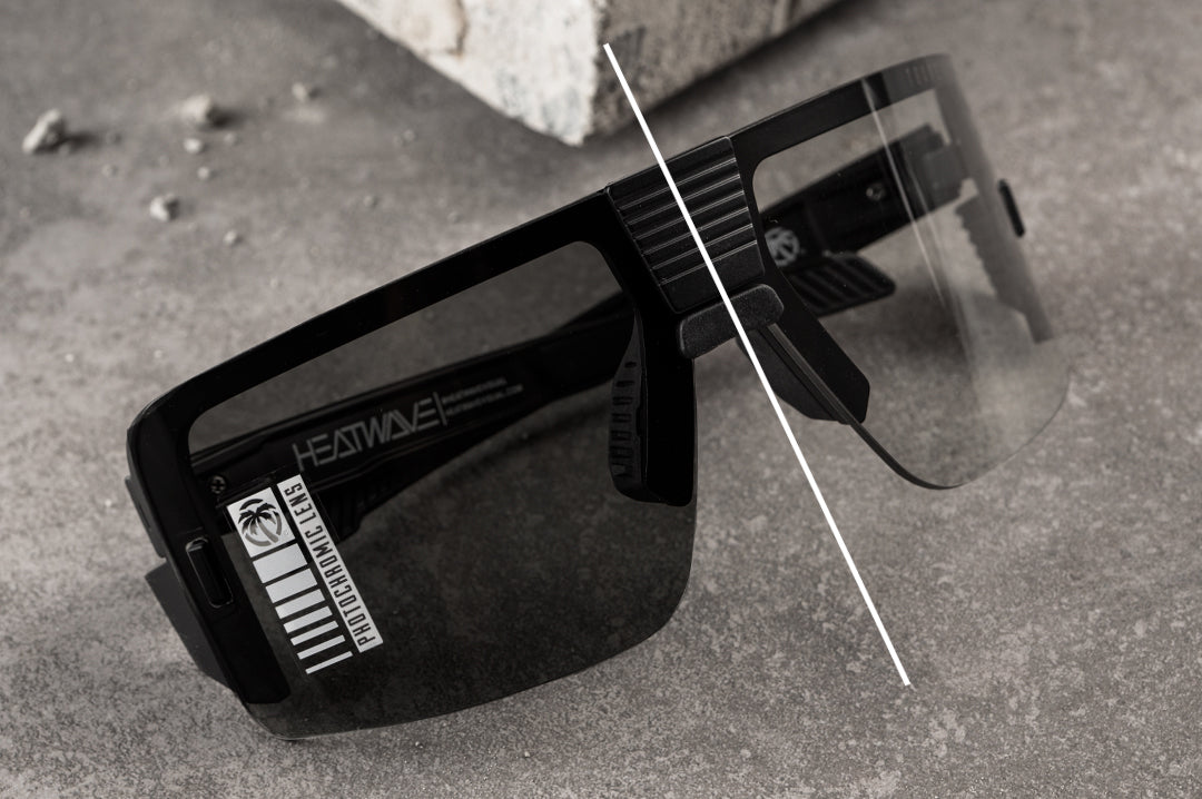 On the concrete floor is the Heat Wave Visual Vector Sunglasses with black frame and photochromic lens.