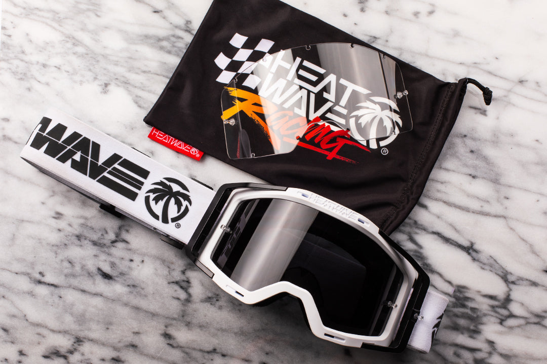 Heat Wave Visual MXG 250 Motosport Goggle in the billboard icon white color way laying on a table. 
