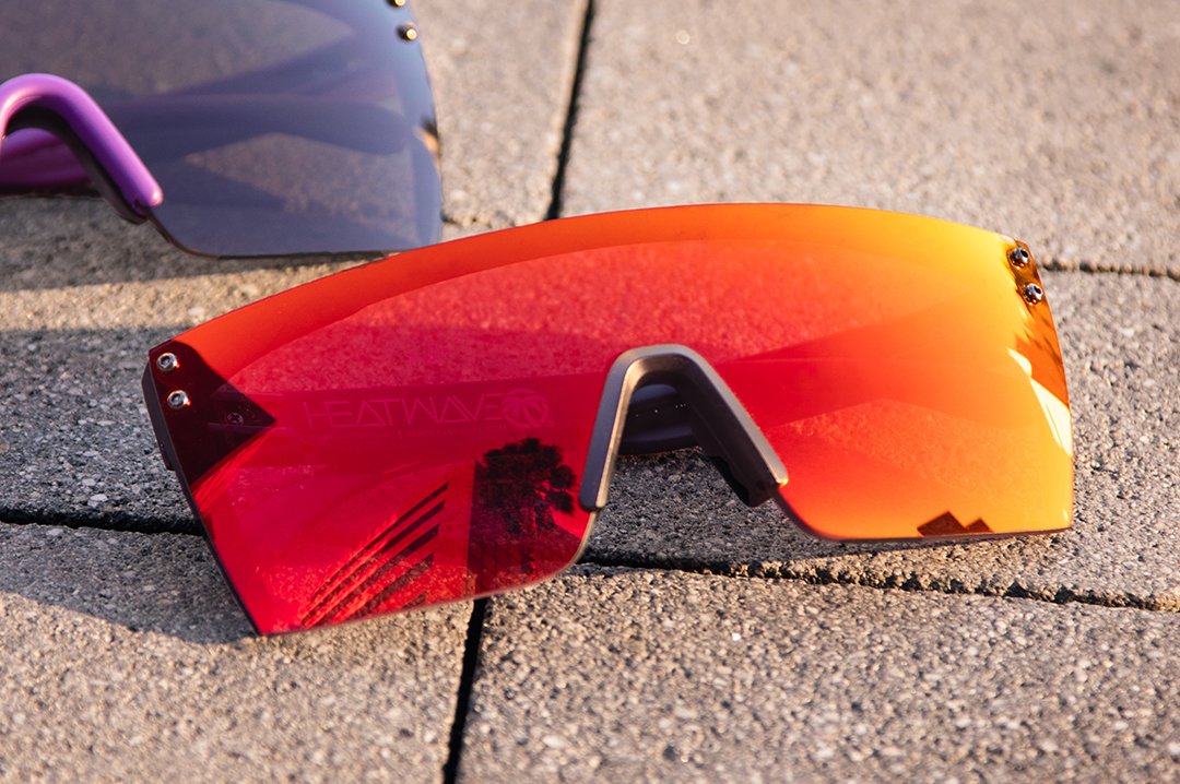 Heat Wave Visual Lazer Face Z87 Sunglasses with black frame and firestorm red lens lying on concrete floor.