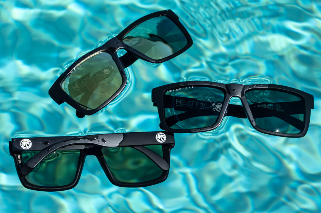 3 pairs of Heat Wave Visual Vise Floating Sunglasses floating in a swimming pool.