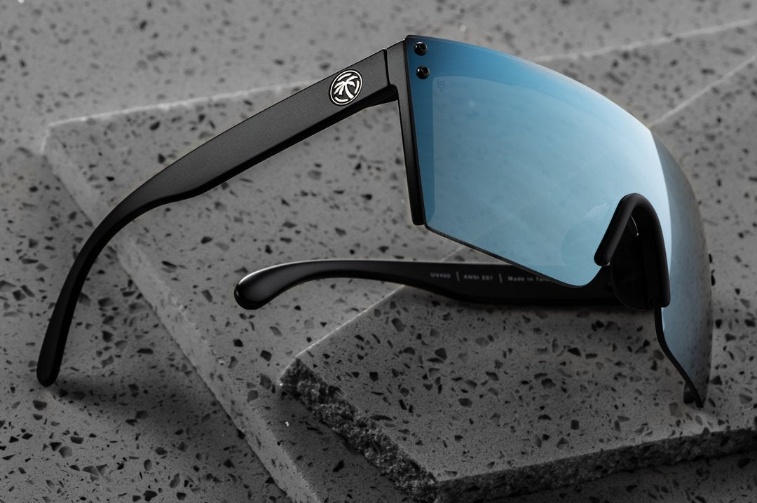 Side view of Heat Wave Visual Lazer Face Z87 Sunglasses with black frame and arctic chrome lens on slabs of granite.