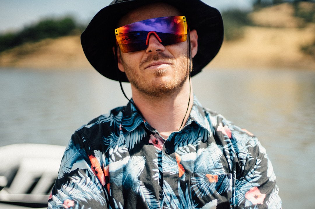 Man on boat wearing Heat Wave Visual Lazer Face Z87 Sunglasses with black frame and atmosphere red blue lens.