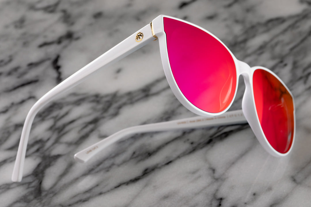 Side view of Heat Wave Visual Womens Carat Sunglasses with white frame and spectrum pink lenses.