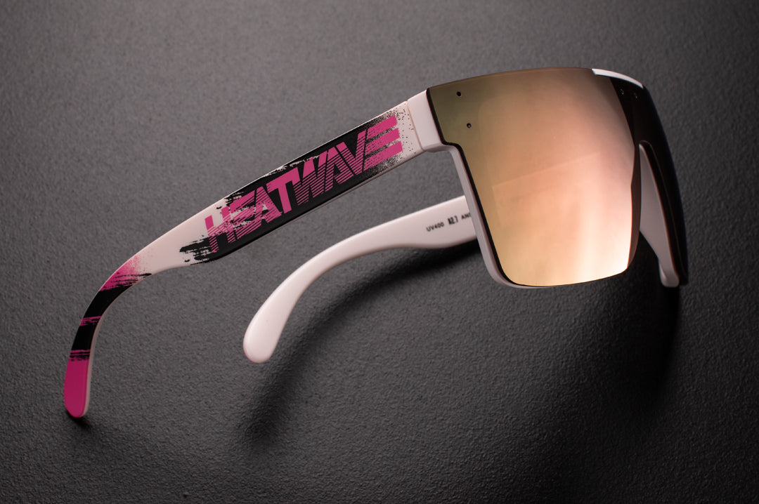 Side view of Heat Wave Visual Quatro Sunglasses with white frame, pink logo print arms and rose gold lens.