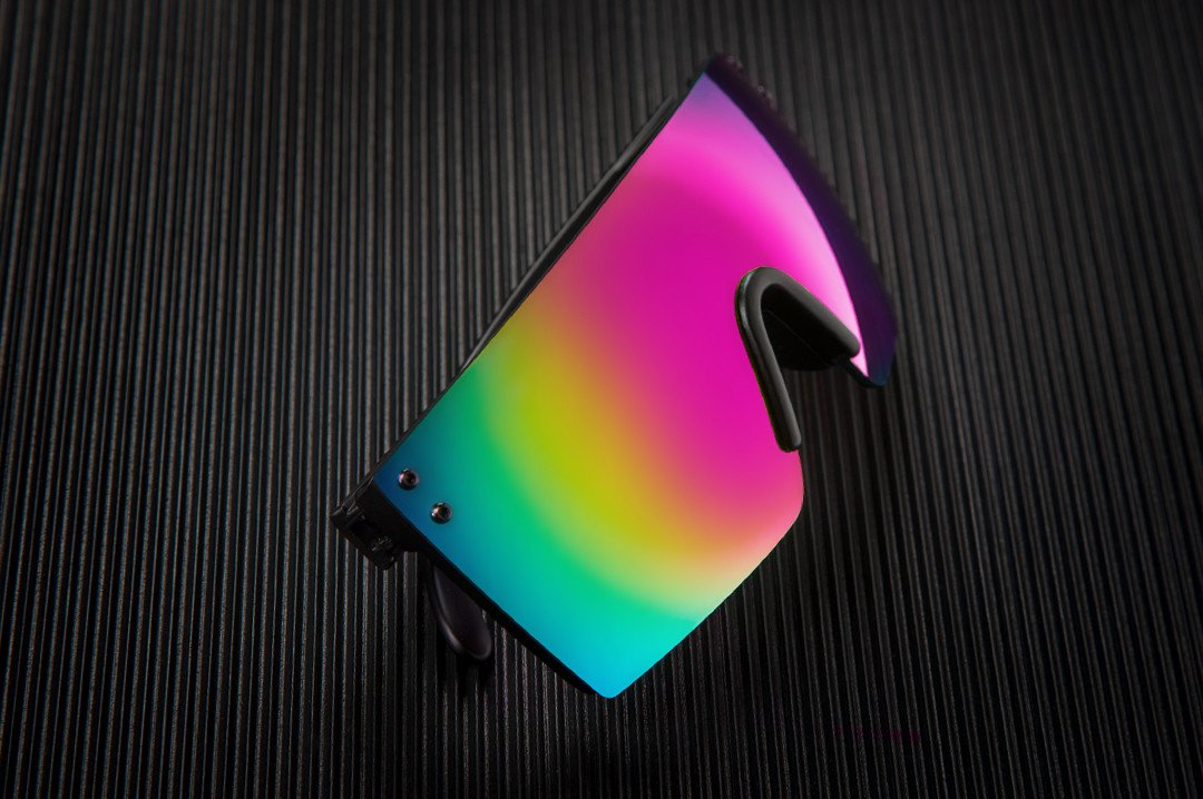 Heat Wave Visual Lazer Face Z87 Sunglasses with black frame and spectrum pink yellow lens on a black table.