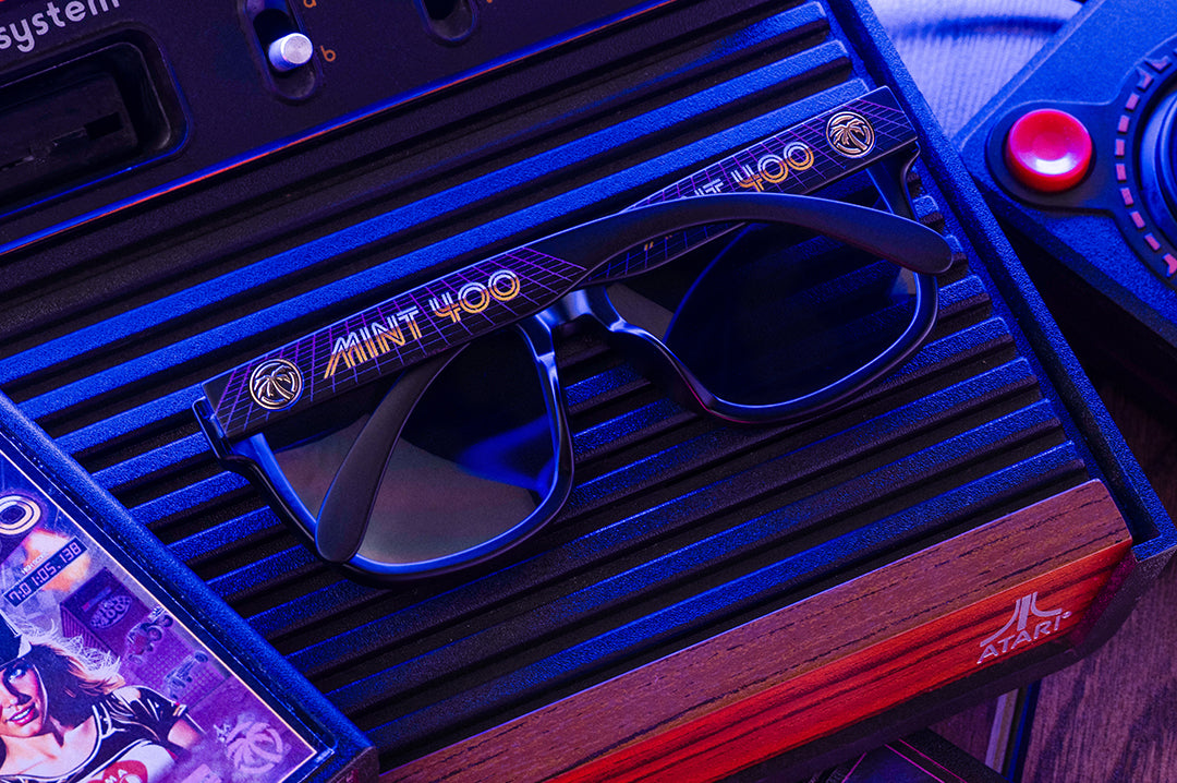 Glasses with 'Mint 400' branding on a vintage Atari console.