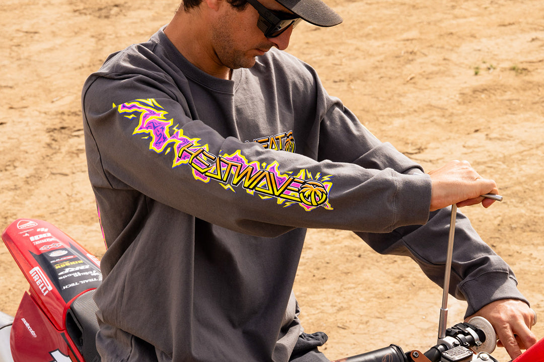 Man wearing the Heat Wave "Sorry Babe" LONG SLEEVE T-Shirt on a dirt bike in the desert.