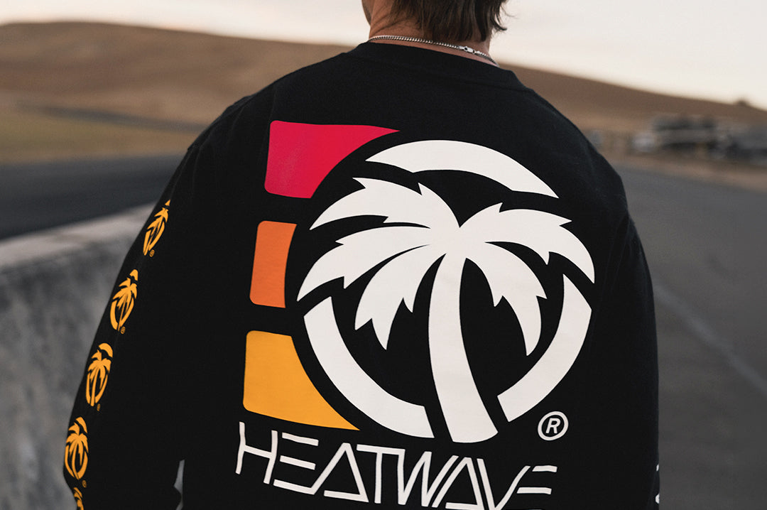 Man wearing the Heat Wave 3 Stripe Long Sleeve T-Shirt - Black showing the backside