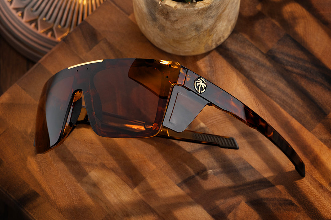 Close up of the Heat Wave Z87+ Performance Quatro Tortoise sunglasses with side shields on wooden table.
