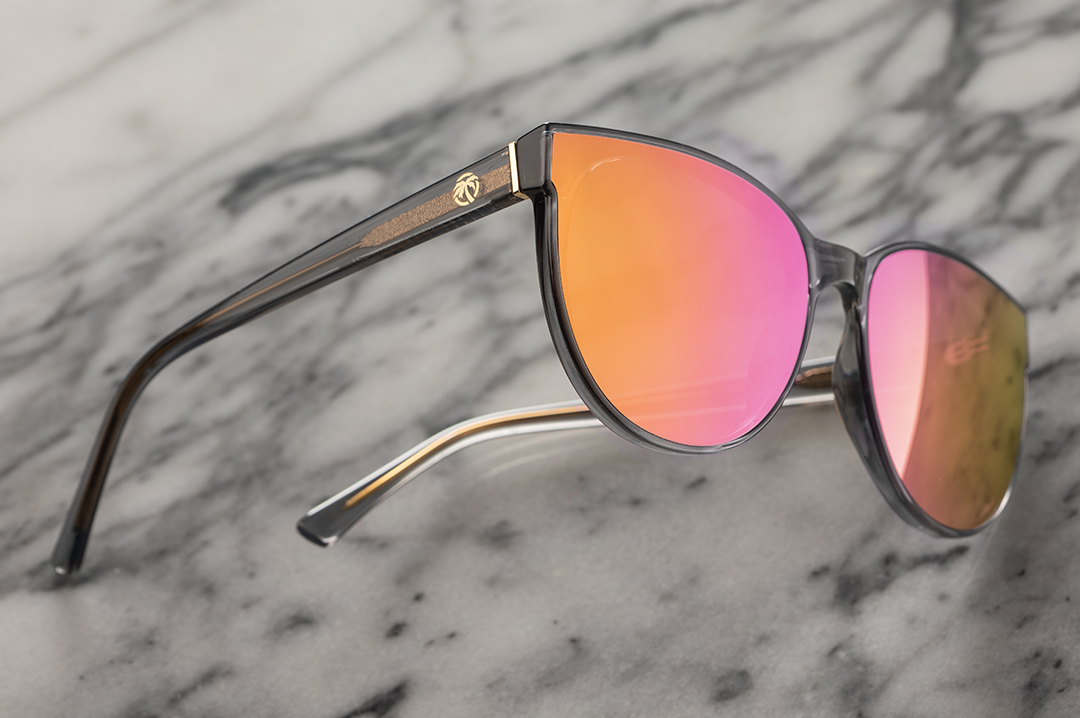 Lying on a marble slab is the Heat Wave Visual Carat Sunglasses with quartz frames and rose gold lenses.