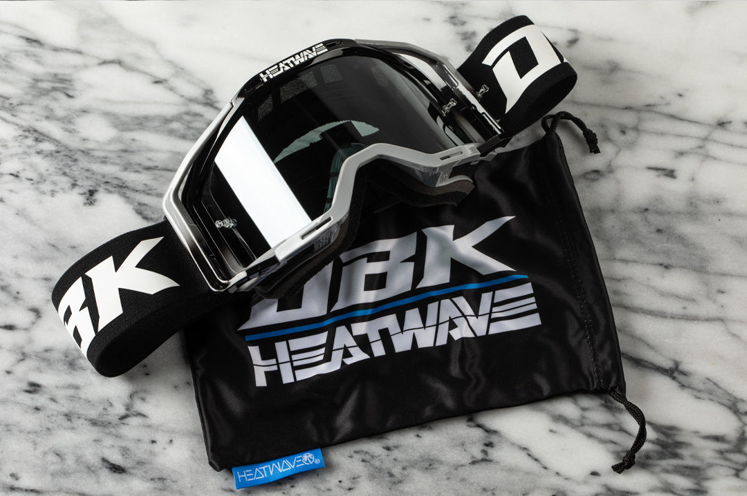 Laying on a table is the Heat Wave Visual x DBK MXG-250 Moto Goggles.