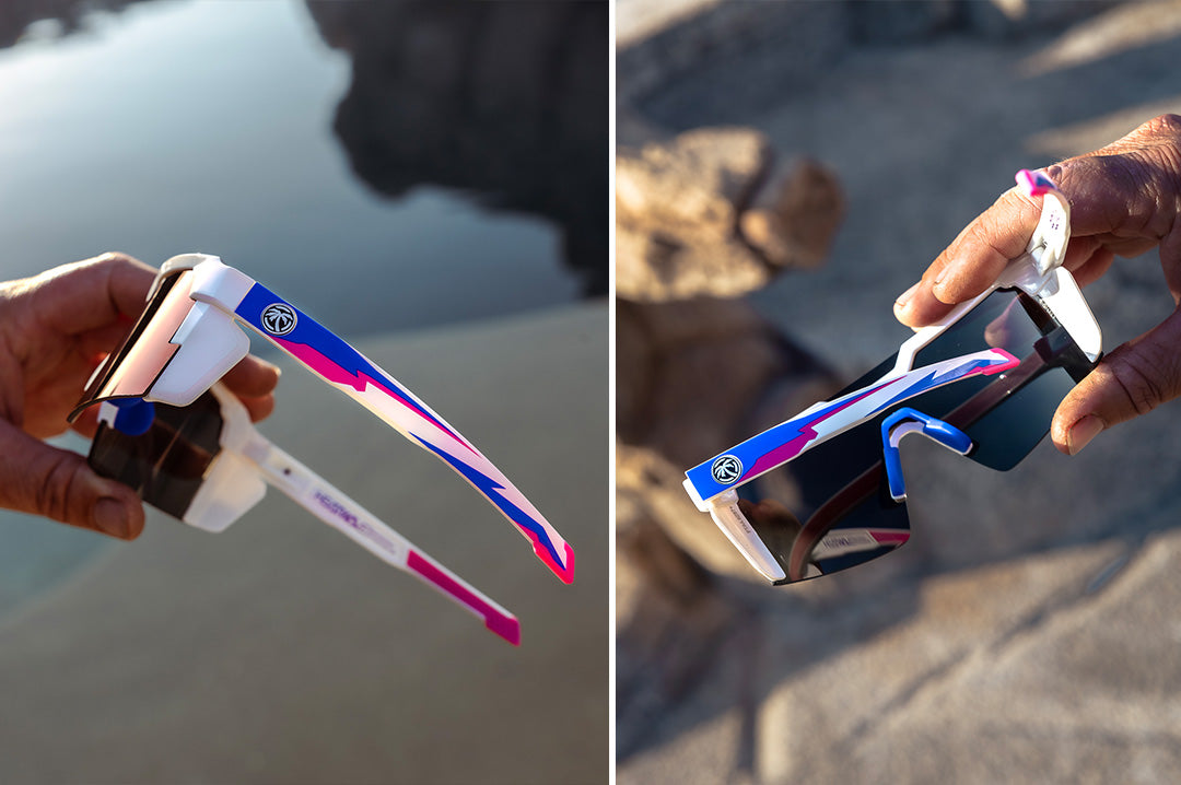 Hand holding the Heat Wave Visual Future Tech Sunglasses with gloss white frame, wild print arms and atmosphere lens.