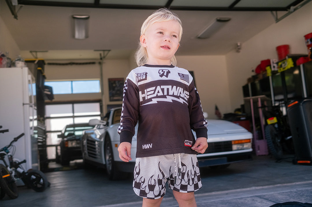 Child wearing the Little Trouble x Heat Wave Kids Long Sleeve Jersey - Black