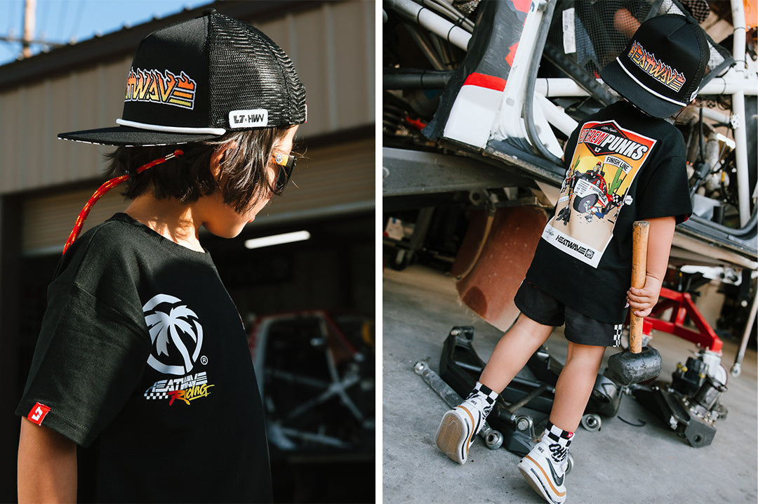 Young boy wearing the Little Trouble X Heat Wave Kids T-Shirt holding a tool.