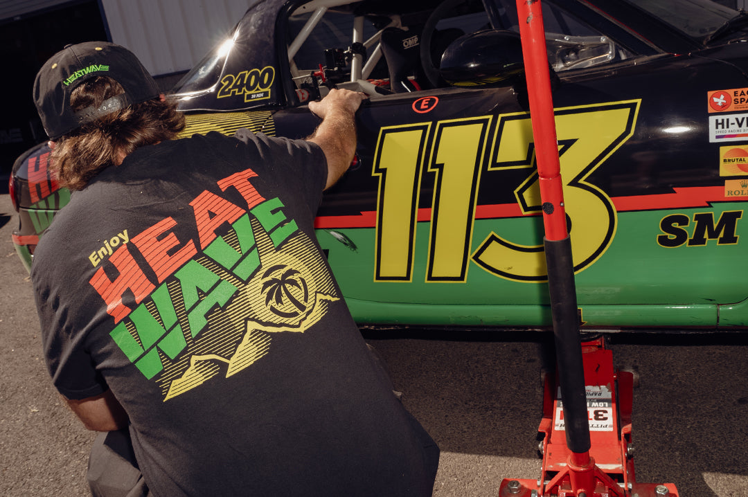 Justin rocking on the Mello Wave Miata wearing the Heat Wave Visual Mello Wave T-shirt. 