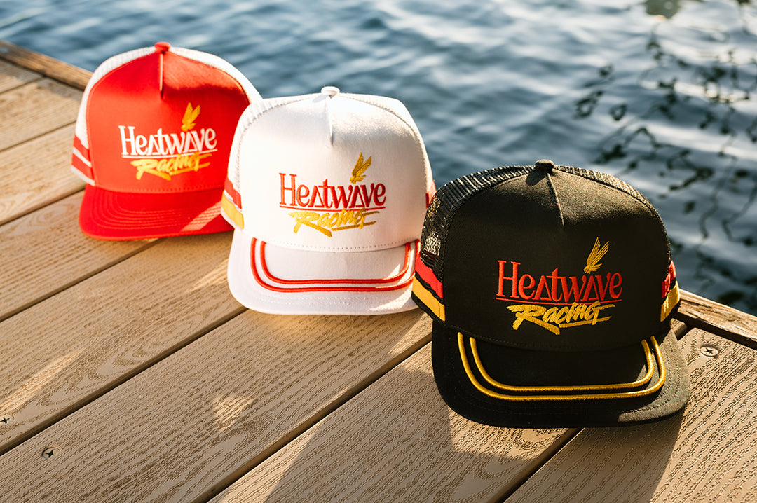 Three colors of the Offshore hats on a deck by the lake