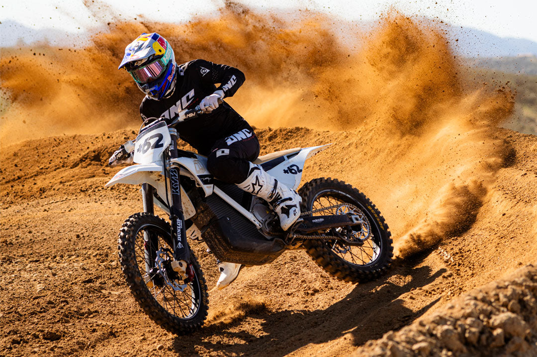 Male model wearing Heat Wave Hydro Aquastone Goggles with Ultra Violet Lens and Aqua colored strap while riding dirt bike