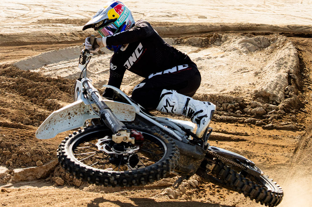 Model wearing Heat Wave Hydro Aquastone Goggles with Ultra Violet Lens and Aqua colored strap while riding dirt bike