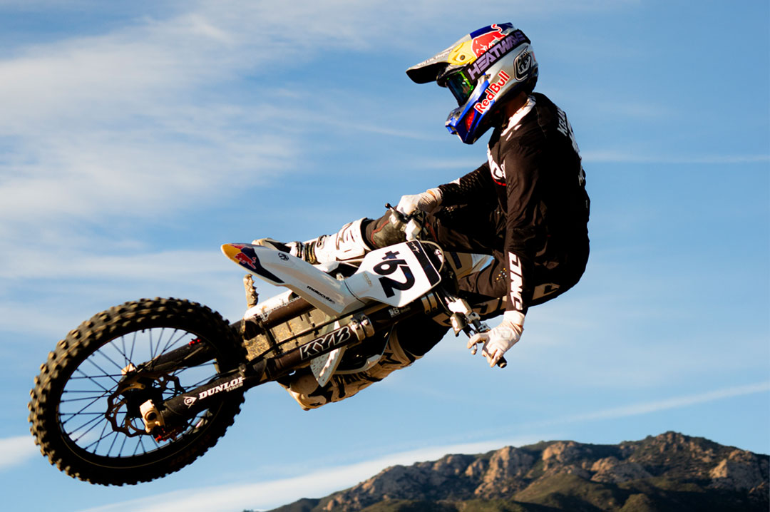 Male model wearing Heat Wave Visual MXG 250 Motorsport Goggle in the Hydro Digger color way with a Piff lens.