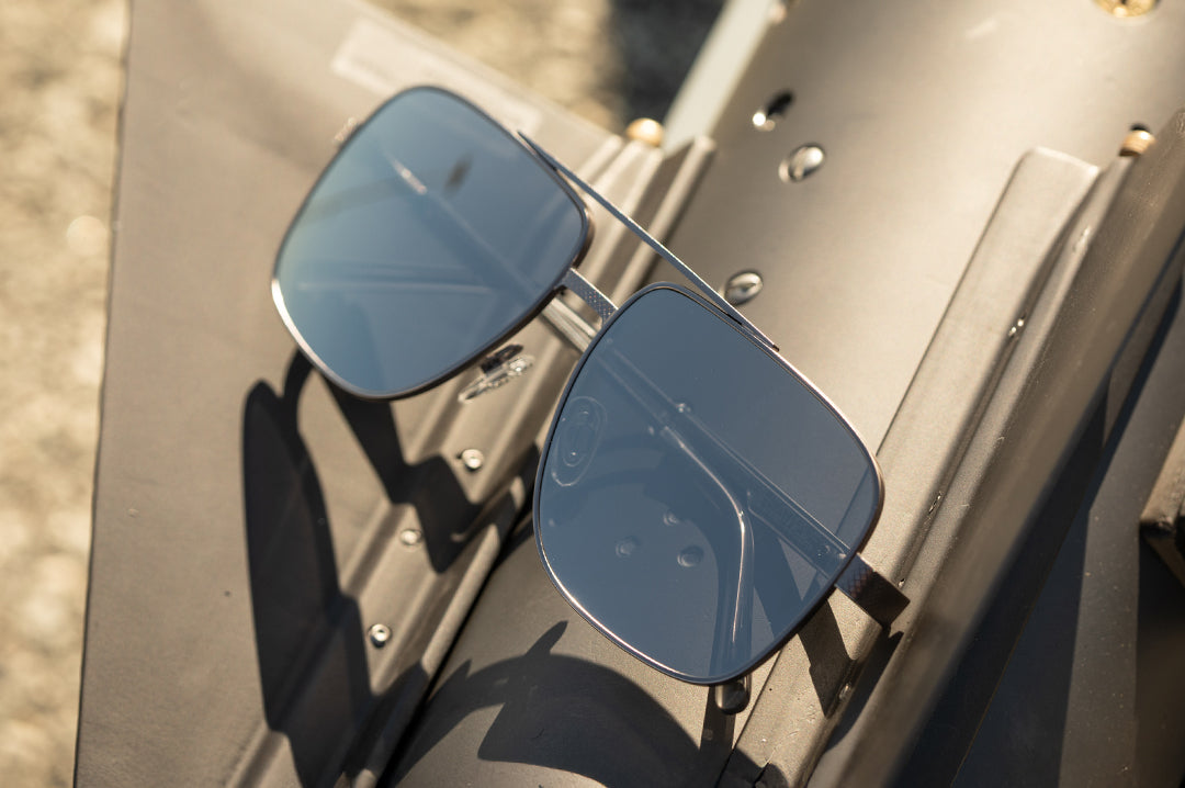 Heat Wave Visual Nimitz Sunglasses with gun metal frame and silver lenses sitting on top of a missile.