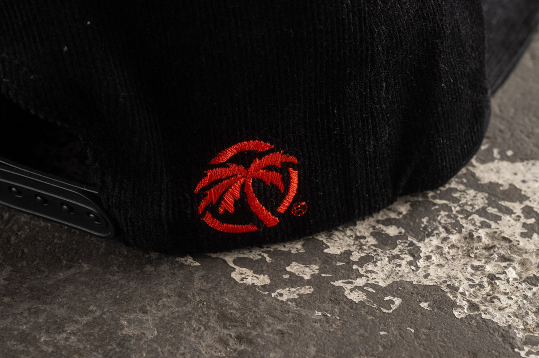 Black stitched logo on the Heat Wave Visual Black Magic Black Cord Hat.