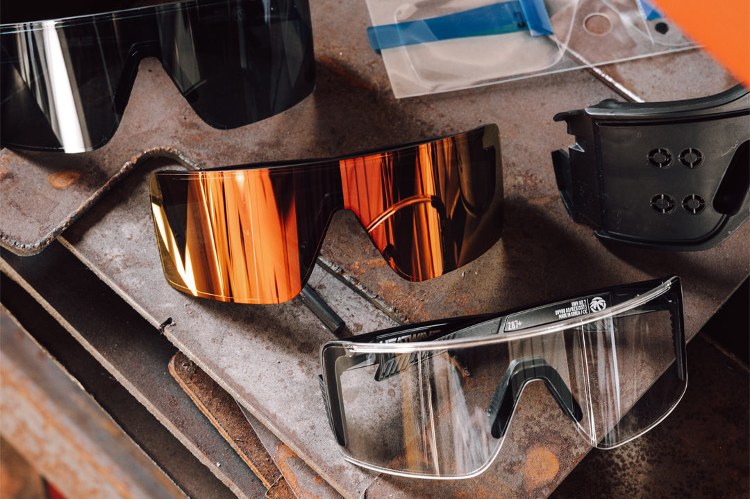 Three Skynet glasses with the Skynet Sunglasses: LPF Replacement Jig and Skynet Replacement LPF Lens Protection Film sitting on top of wood