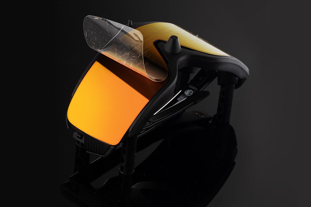 The Skynet Replacement LPF Lens Protection Film peeling off glasses sitting on top of Skynet Sunglasses: LPF Replacement Jig