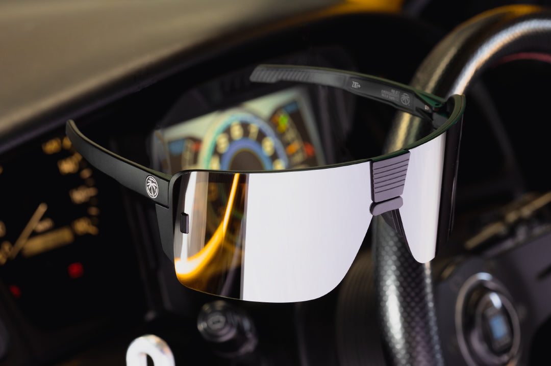Floating in midair are Heat Wave Visual Vector Sunglasses with black frame and silver lens.