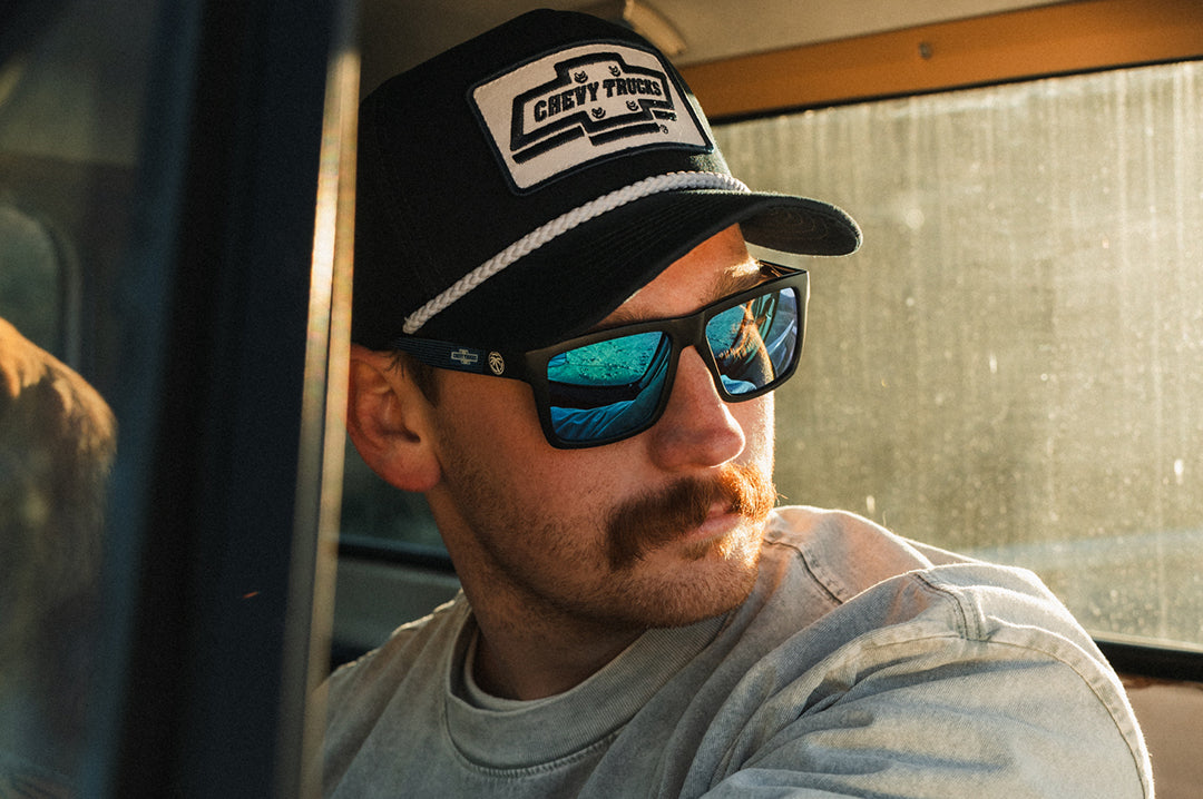 male model wearing Heat Wave Visual Vise Sunglasses with black frame, Chevy Truck print arms and Galaxy lens.