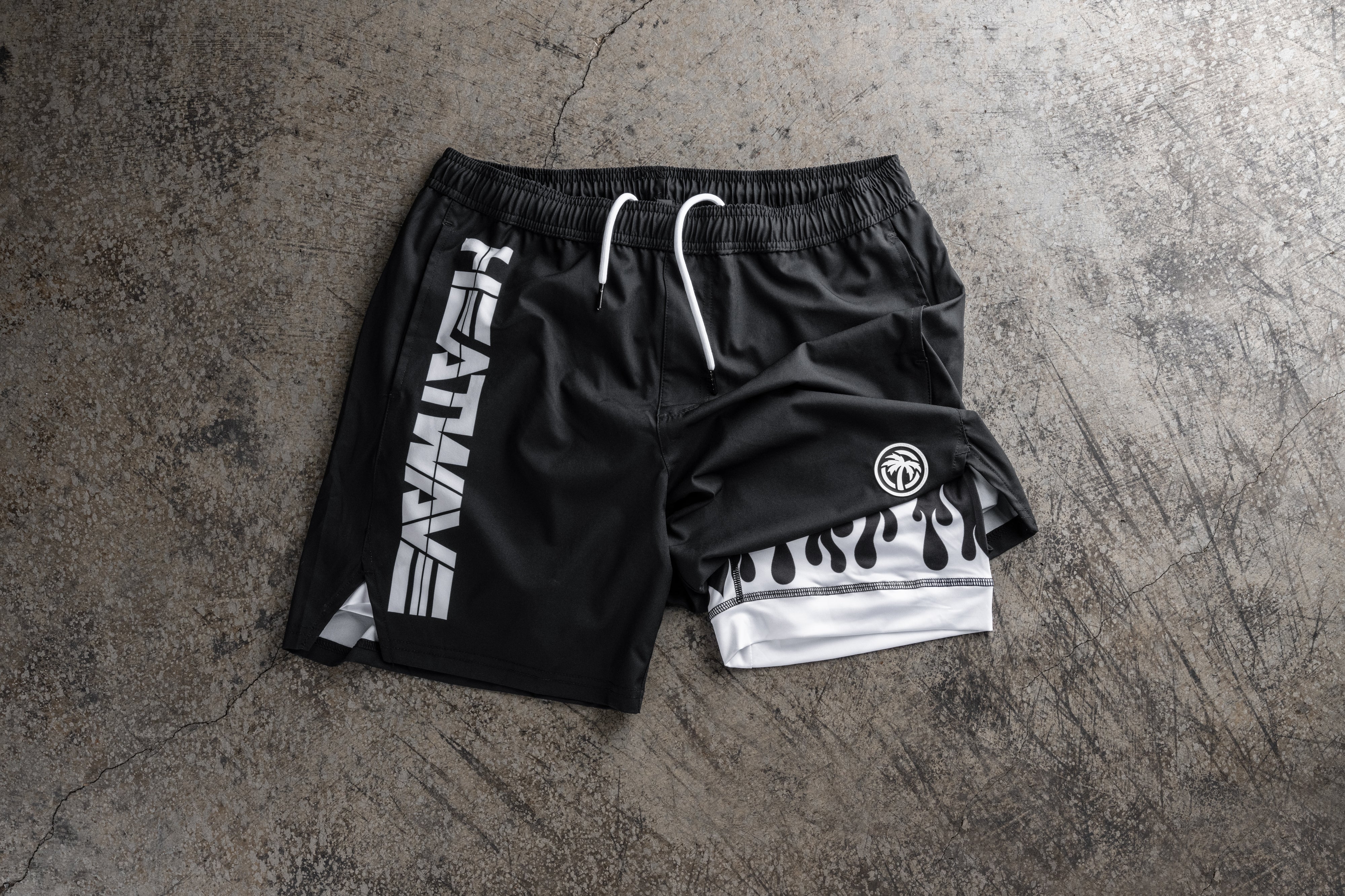 Lying on a concrete floor is the Heat Wave Visual White Flame Performance Shorts.