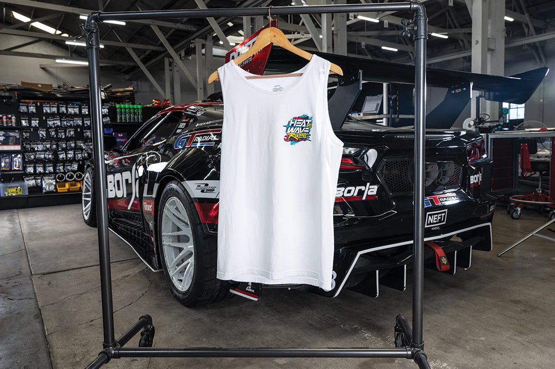 The Heat Wave Y2K White Tank Top hanging in front of a car