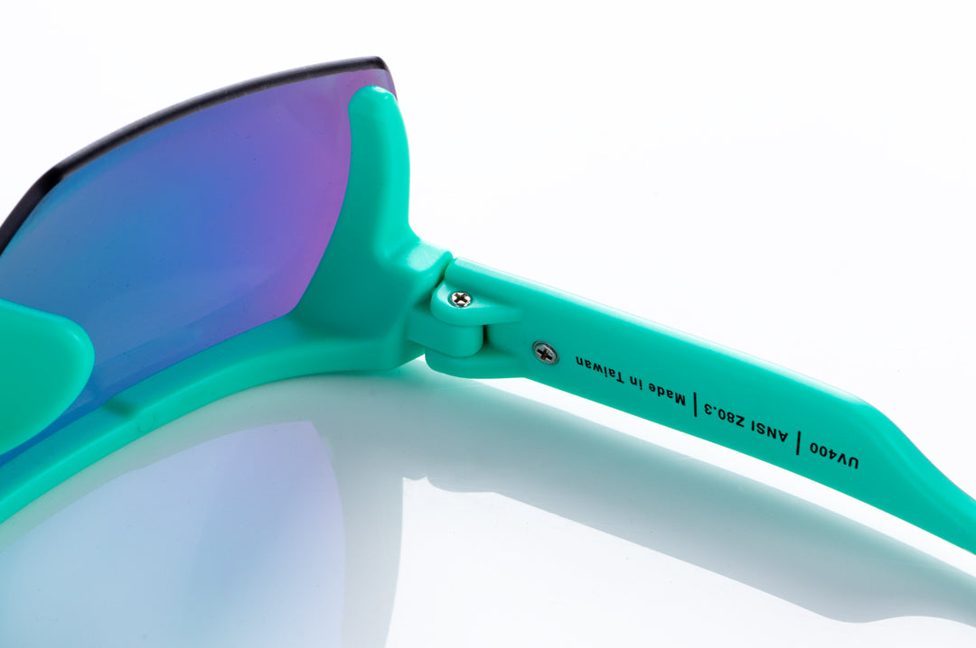 Detail shot of hinge on the Heat Wave Visual Lazer Face Kids Sunglasses with teal frame, brush print arms and spectrum pink yellow lens