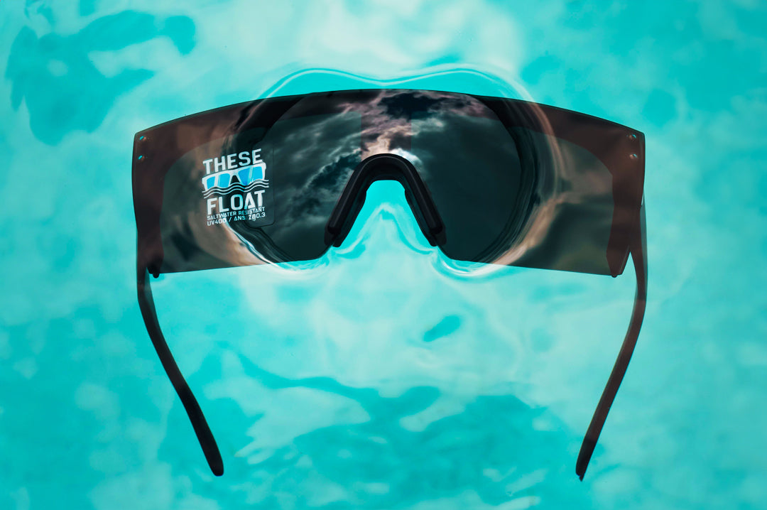 Heat Wave Visual H2O Lazer Face Sunglasses with black frame and black lens floating in water. 