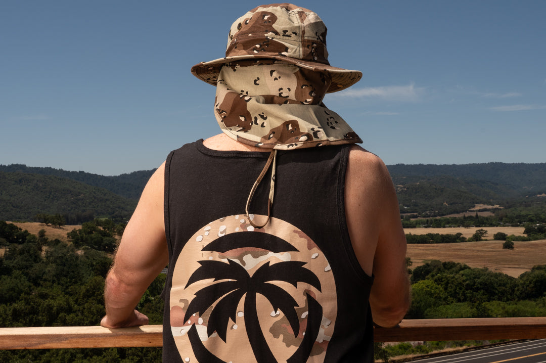 Back of man wearing the Heat Wave desert camo boonie hat with matching tank top in black