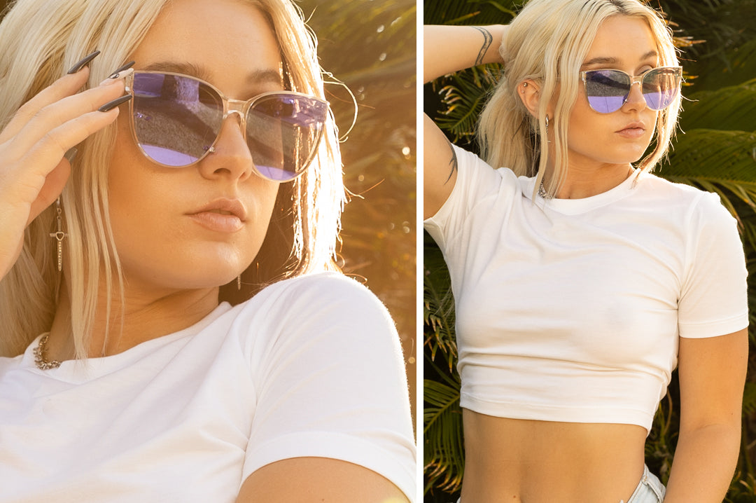 Young women outside wearing the Heat Wave Visual Carat Sunglasses with clear sparkle frame and ultra violet lenses.