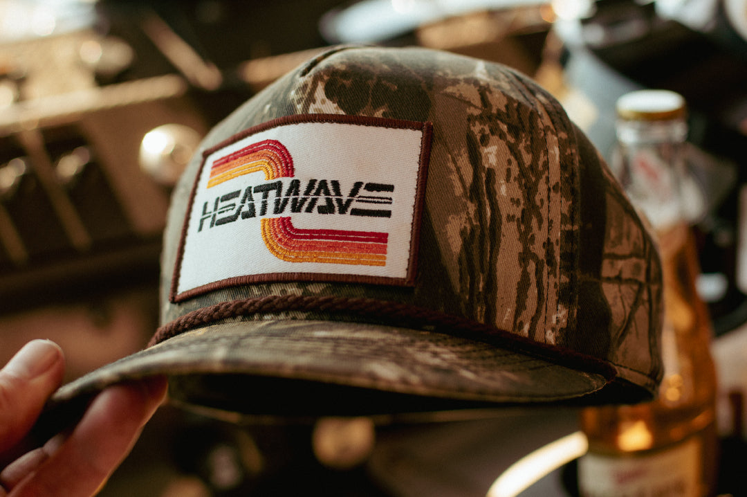 A hand holding the Heat Wave Visual Chopper Hunter hat.