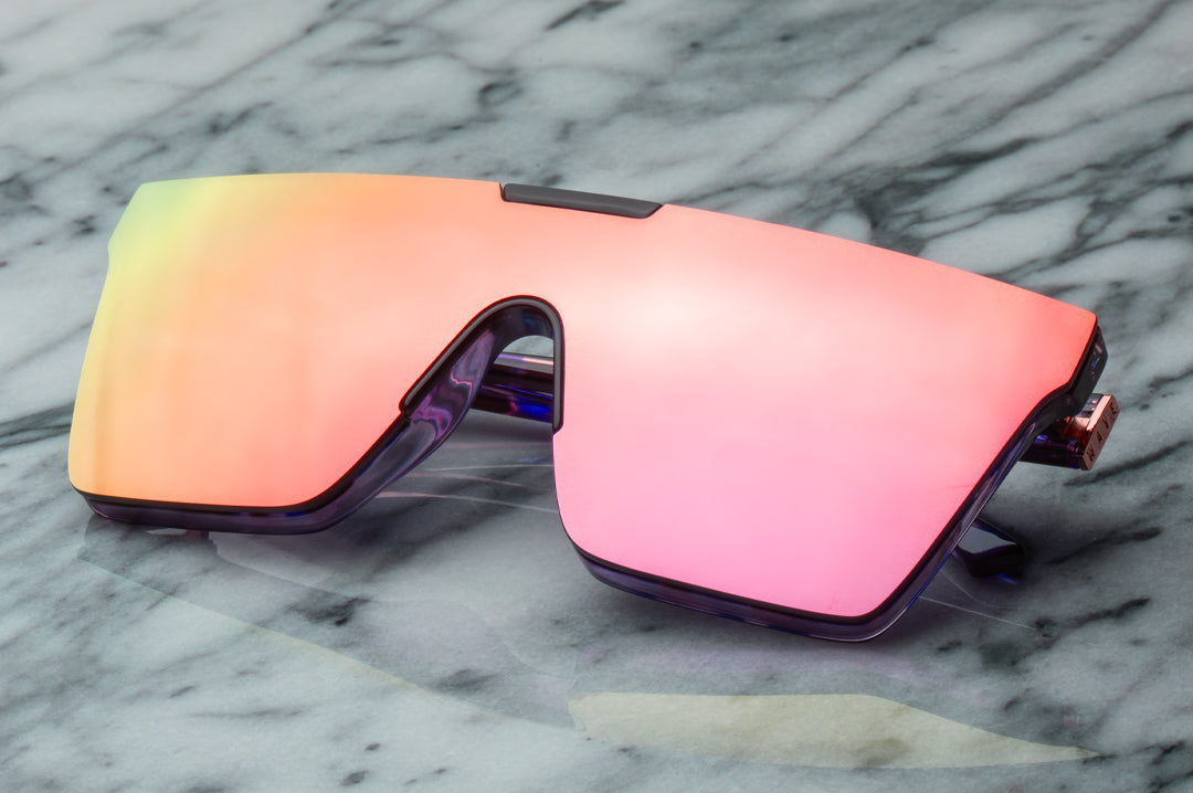 Sitting on a marble table is the Heat Wave Visual Women's Clarity Sunglasses with velvet tortoise frame and rose gold lens.