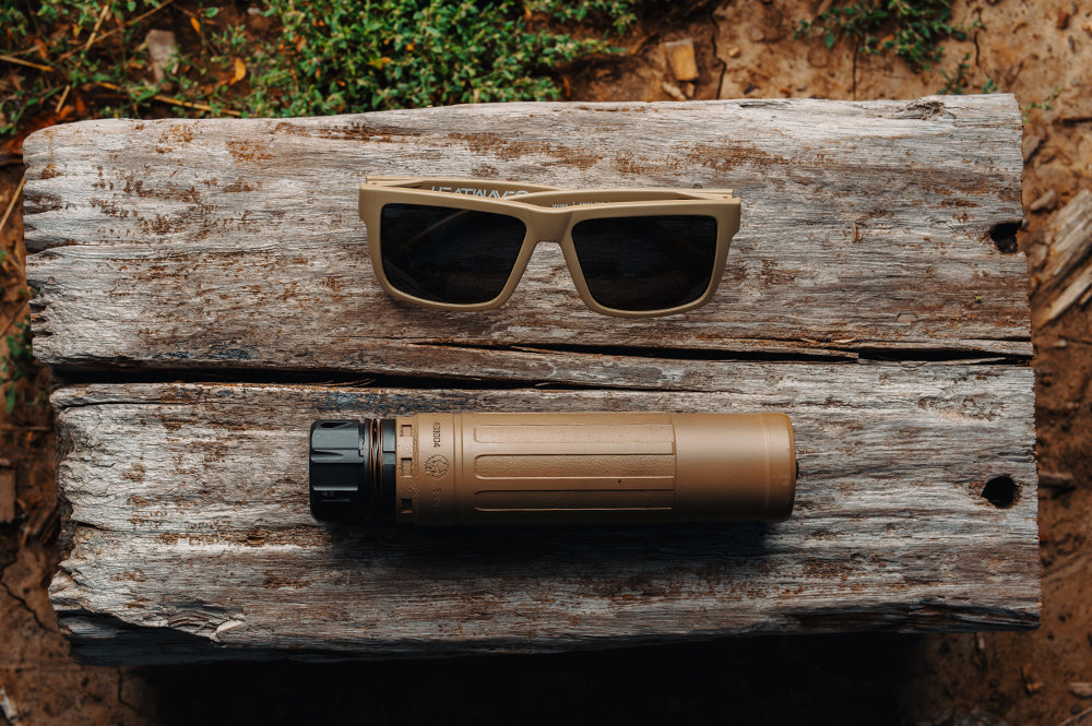 Heat Wave Vise Tan Sunglasses and flashlight on a wooden surface with natural background