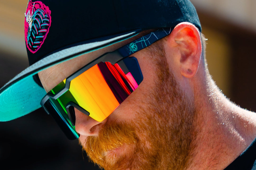 Man wearing Heat Wave Visual and Shreddy collab Future Tech Sunglasses with black frame and spectrum pink lens.