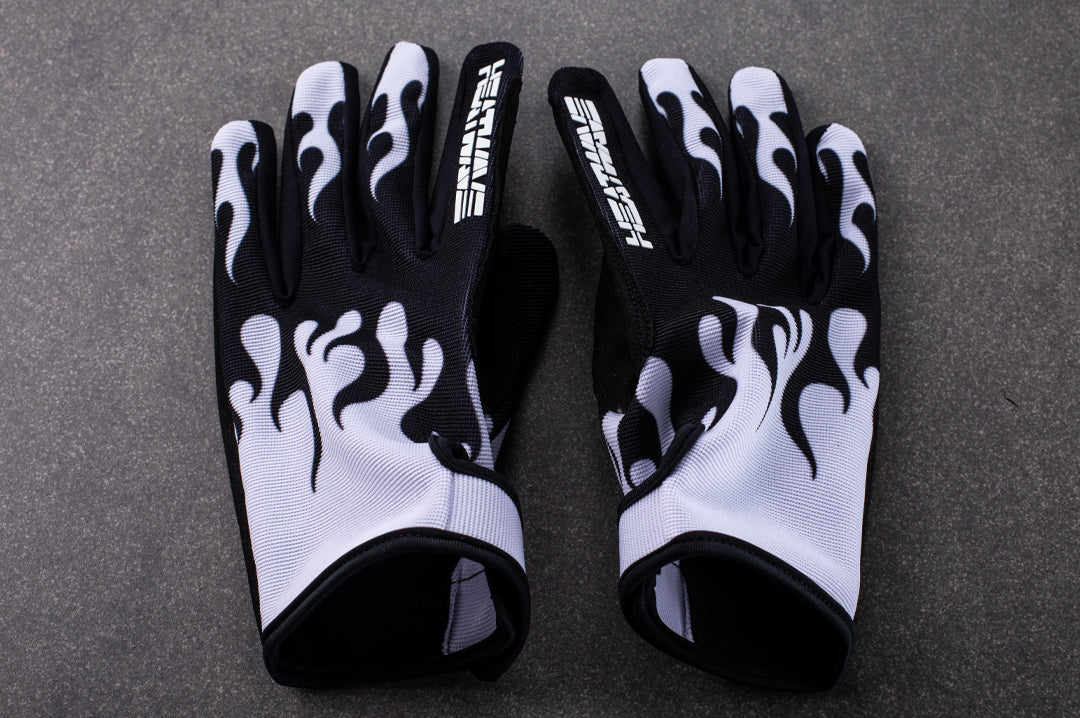 Lying on the floor is the Heat Wave Visual White Flame Moto Gloves. 