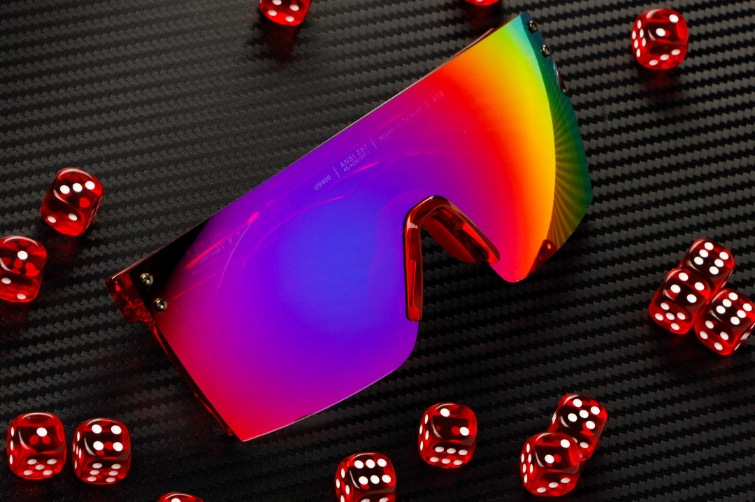 Red dice surrounding the Heat Wave Visual Lazer Face Sunglasses with neon red frame and atmosphere blue red lens.