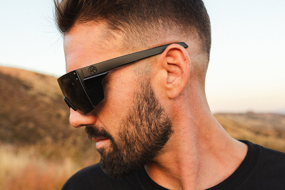 Side profile of young guy wearing the Heat Wave Visual Performance XL Lazer Face Ultra Black Sunglasses.