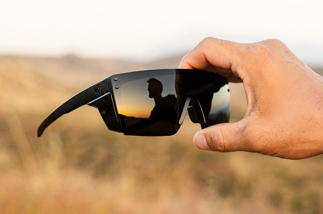 Hand holding up the Heat Wave Visual Performance XL Lazer Face Ultra Black Sunglasses.