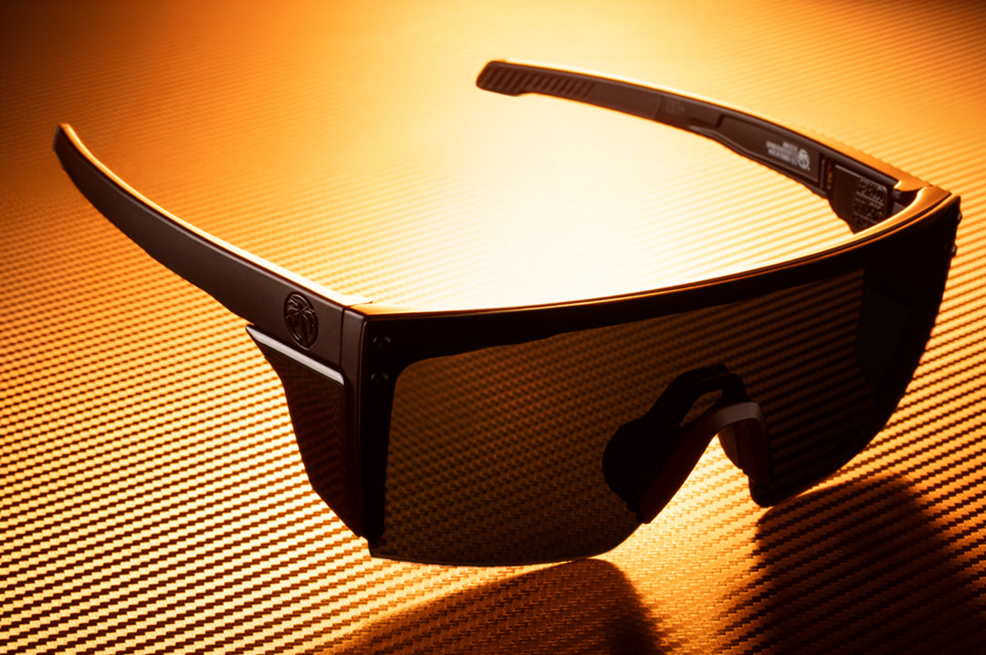 Laying on a table is the Heat Wave Visual Performance XL Lazer Face Sunglasses with black frame and ultra black lens.