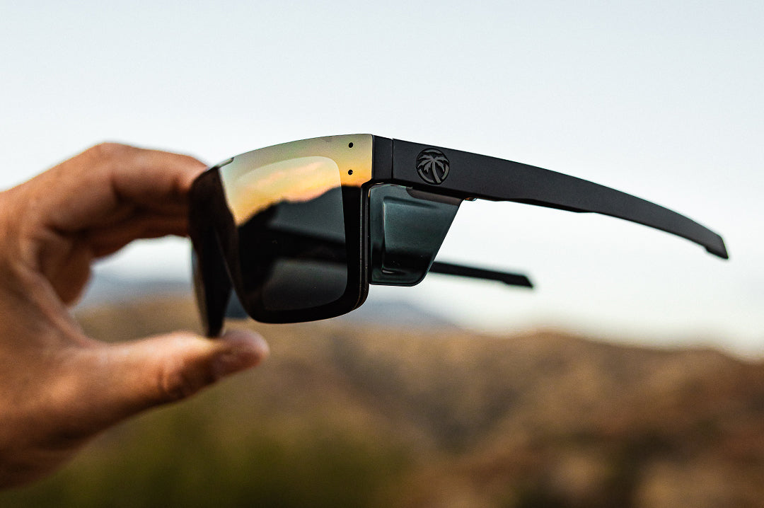 Hand holding the Heat Wave Visual Performance Quatro Ultra Black Sunglasses. 