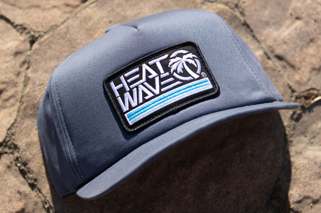 The Heat Wave Visual Retro Stripe Slate Hat lying on the ground. 